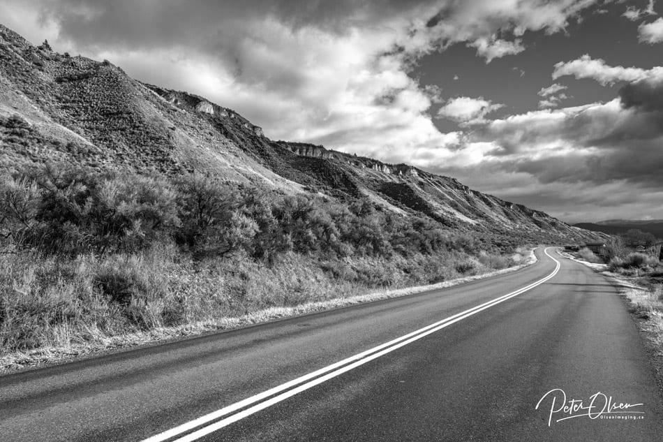 Kamloops grayscale photo of road with mountain and sky with clouds