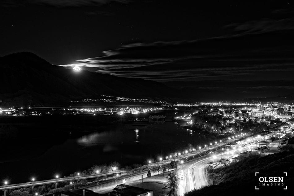 Kamloops black and white photo of cityscape with lit roads and water