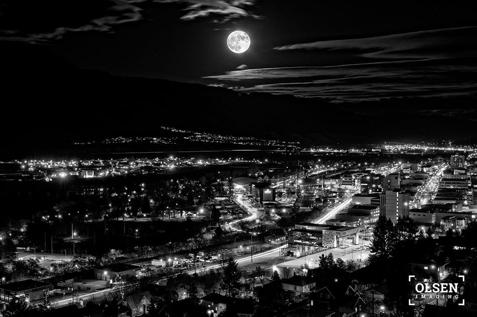 Kamloops black and white photo of city with lights and full moon with clouds