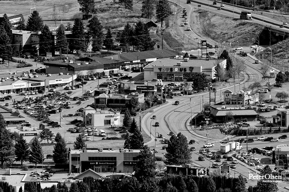 Kamloops black and white photo of the city with tall trees and vehicles