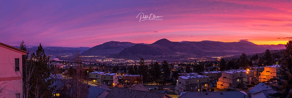 Kamloops City sunlight with purple pink and yellow sky with mountain and city lights