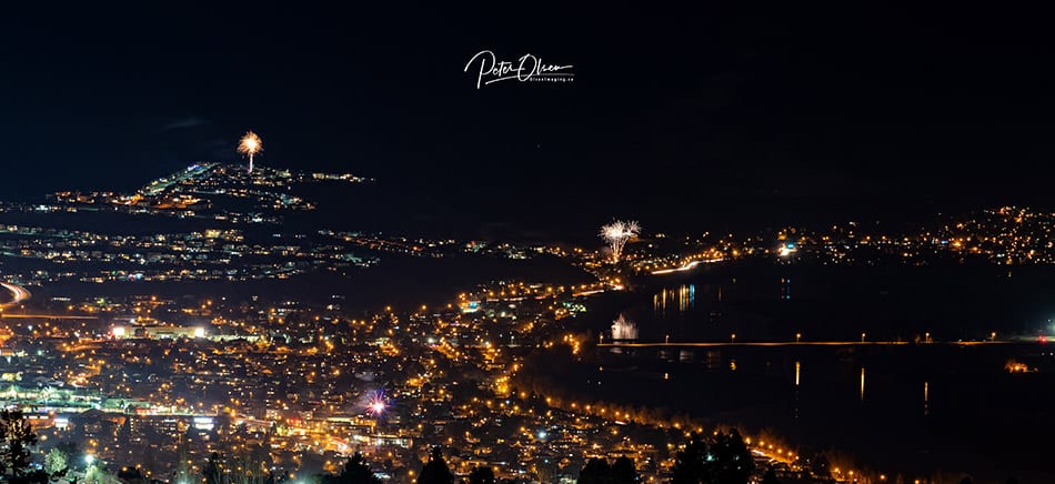 Alt Text: Kamloops City fireworks reflecting off the river and city at night 2