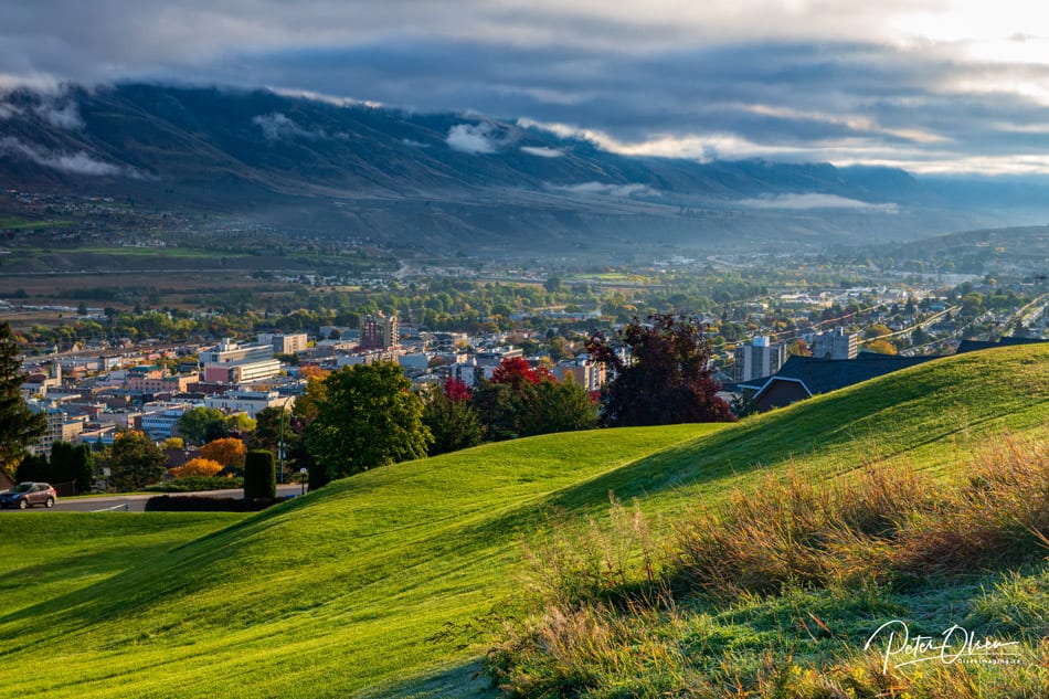 Kamloops City mountain covered with clouds and rolling reen hills with city