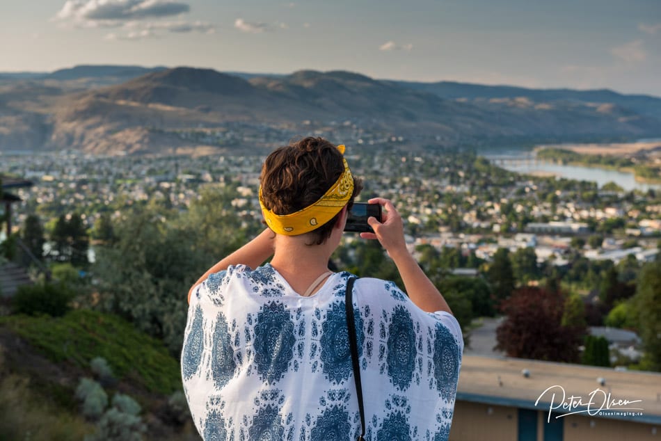 woman with digital camera taking photos wearing a yellow bandana