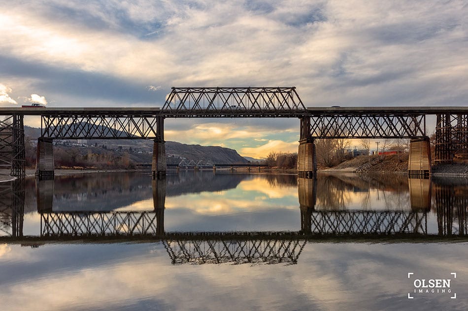 lake reflecting bridge against blue sky with clouds