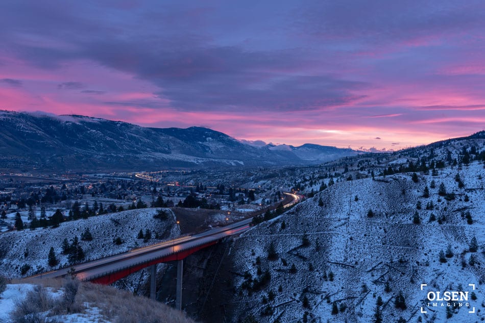 red bridge with snowy mountains and pink purple blue sky