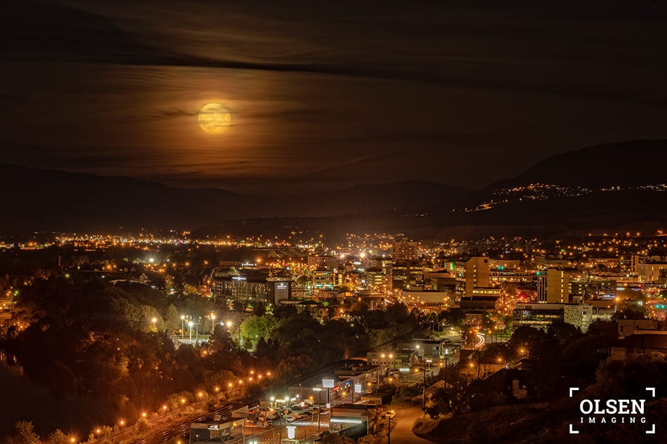 full moon with bright lights and active city