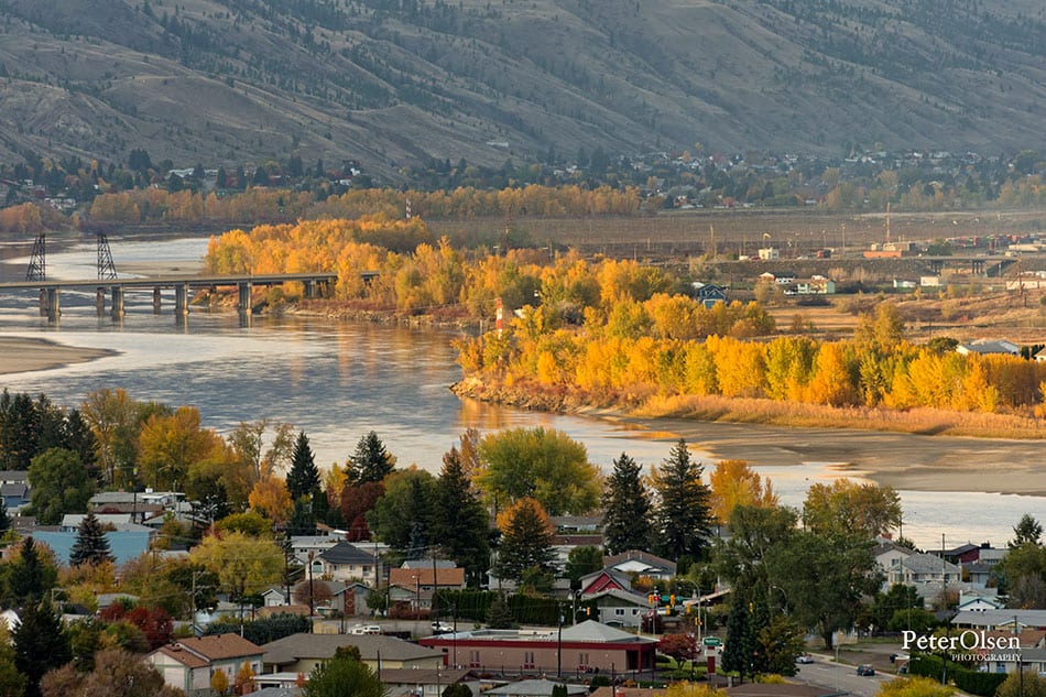 Kamloops City river with green and yellow trees with mountain