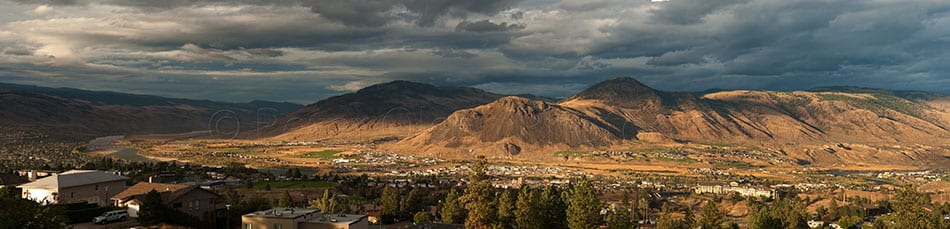Kamloops City grey clouds with mountains and buildings with trees