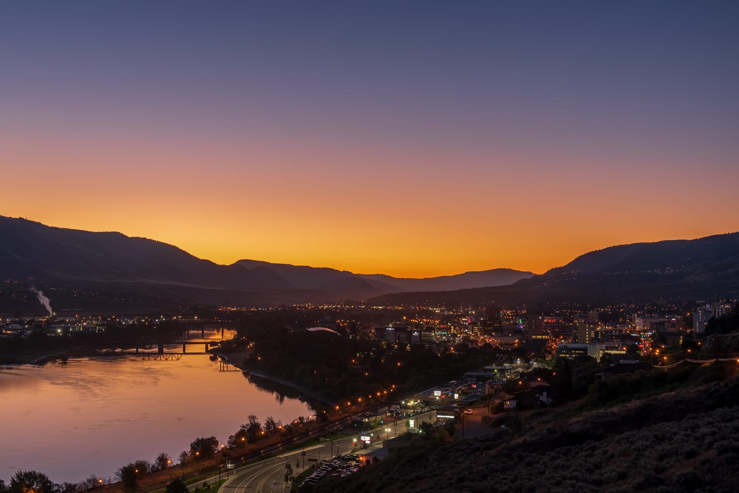 Kamloops City purple yellow and pink sky with city lights and lake