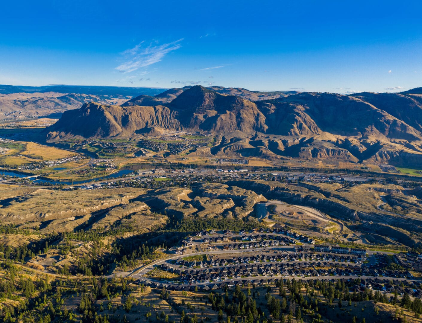 Kamloops City Aerial closeup of mountains and blue sky and road with land terrain