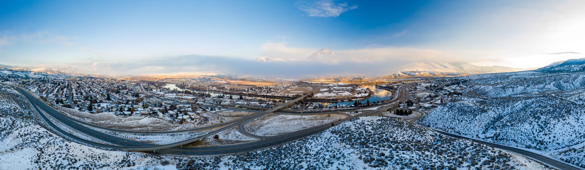 Kamloops City Aerial snowy area with long winding road and sky with clouds