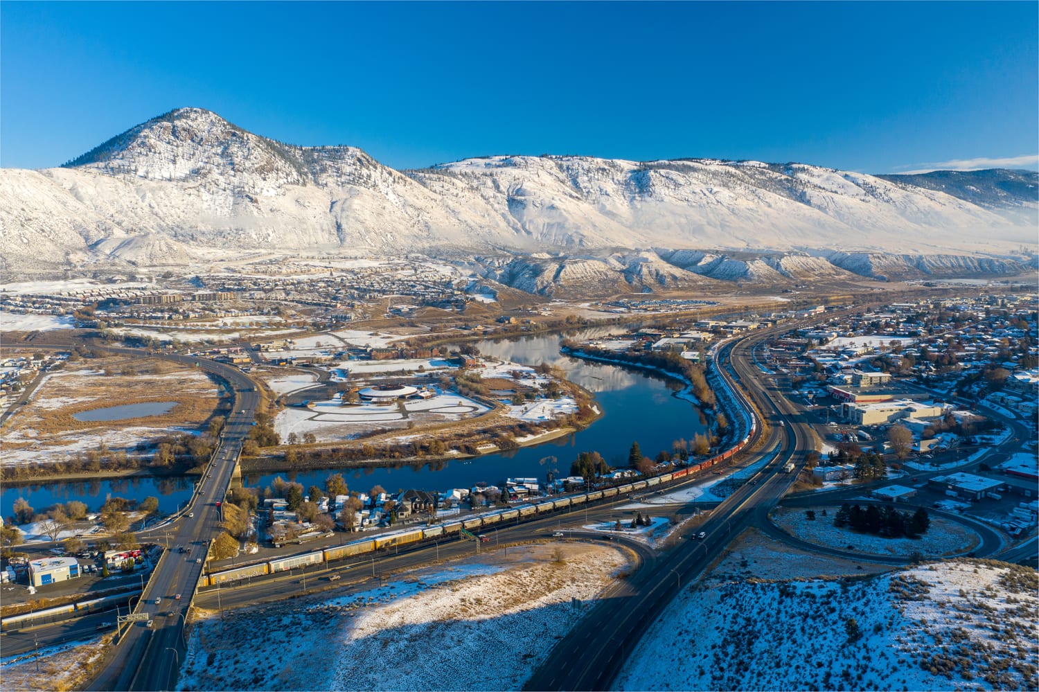 Kamloops City Aerial city with winding road and river with snowy mountain