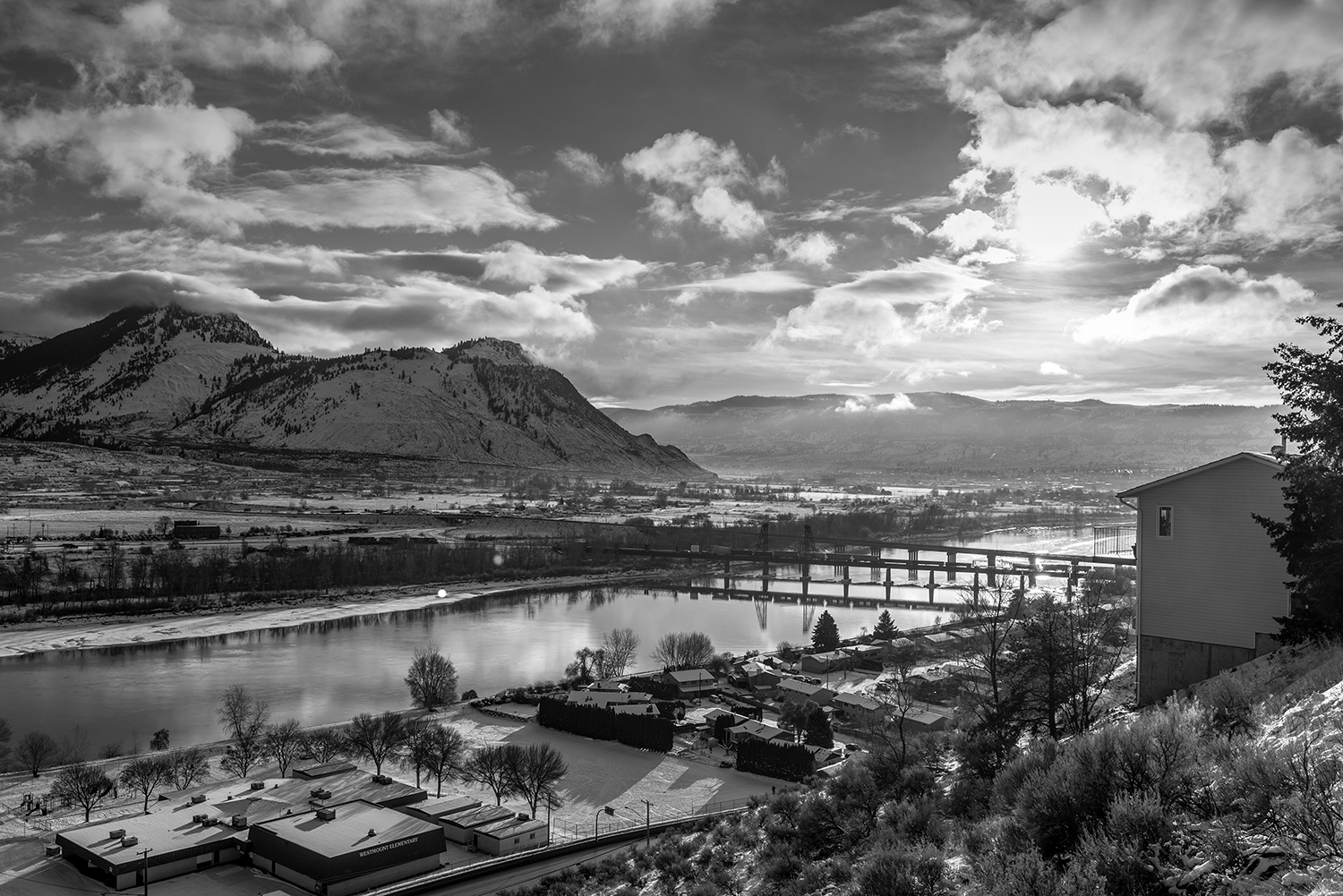 Kamloops grayscale photo of clouds and city with lake