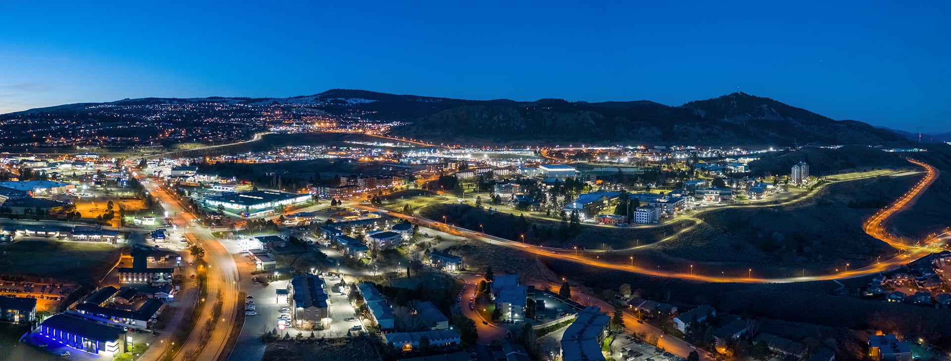 Kamloops City Aerial closeup lit roads with blue sky and neon lights