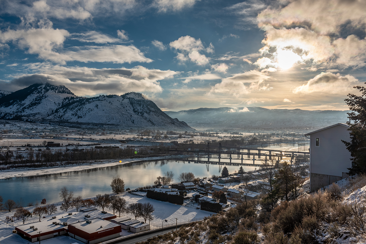 picturesque view of mountains river and city with snow