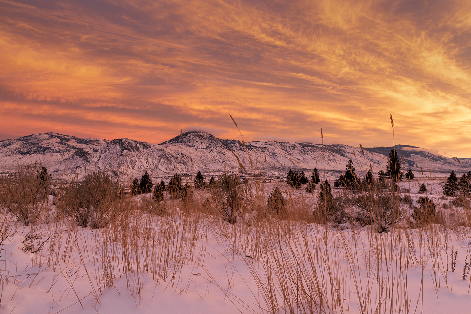Kamloops Landscape yellow and orange sky with clouds and mountain with snow