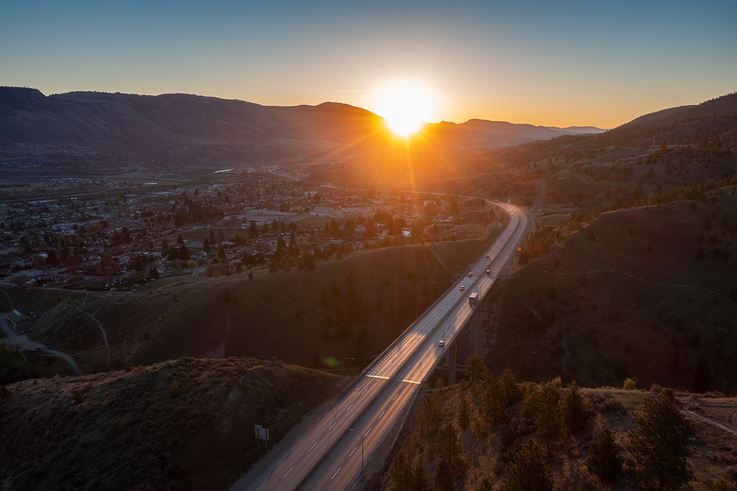 Kamloops City Aerial city with sunlight peeking from mountain and road