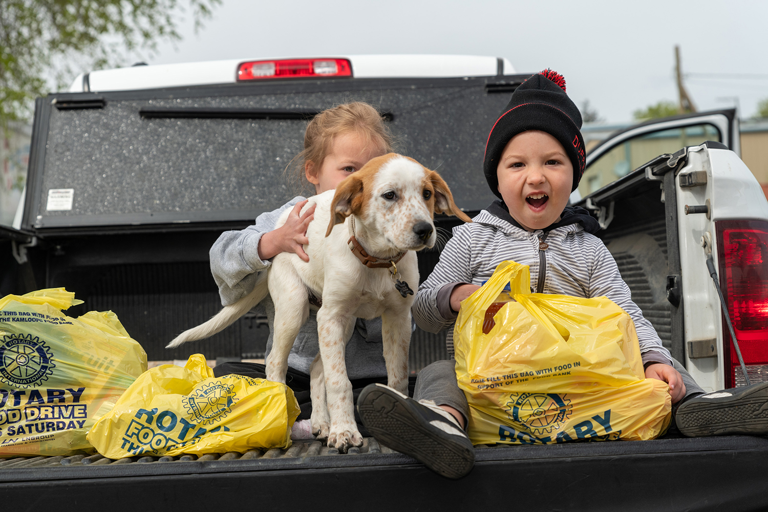 children carrying food bags with dog