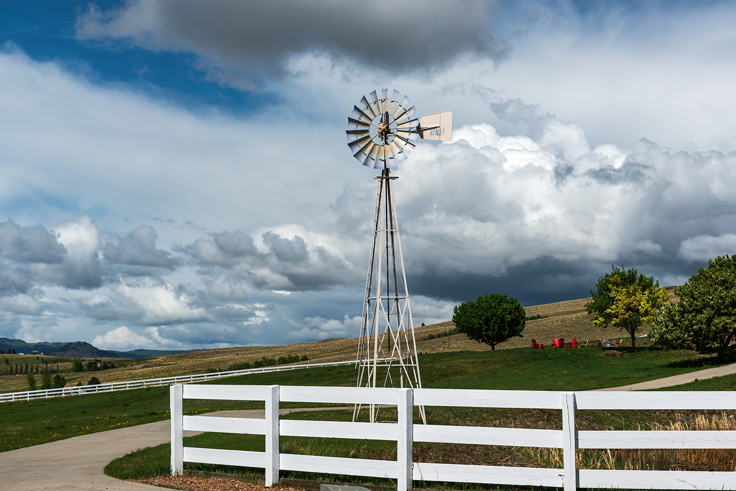 Kamloops rural life windmill with white fence with meadow and trees