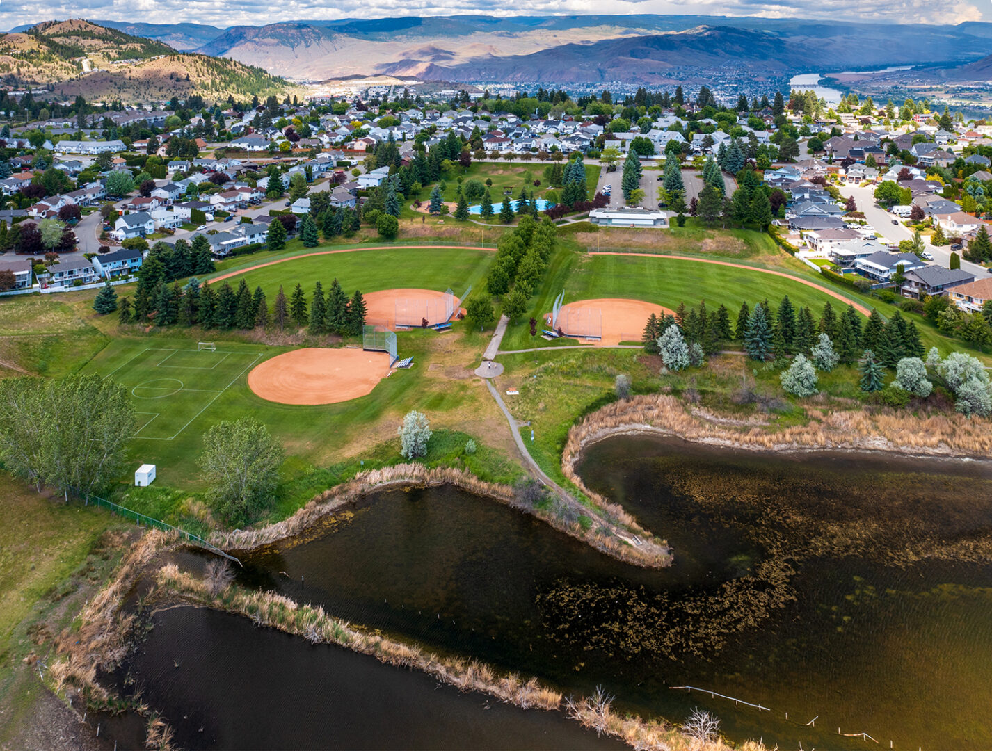 Kamloops City aerial view of landscaped grass and sea with rocks