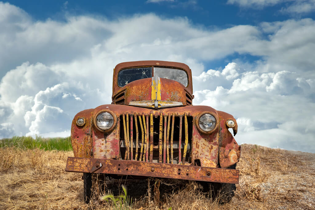 An old rusted bus standing in a field