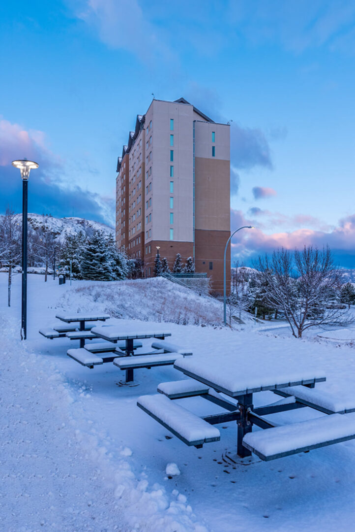 Table and chair covered with snow outside a building