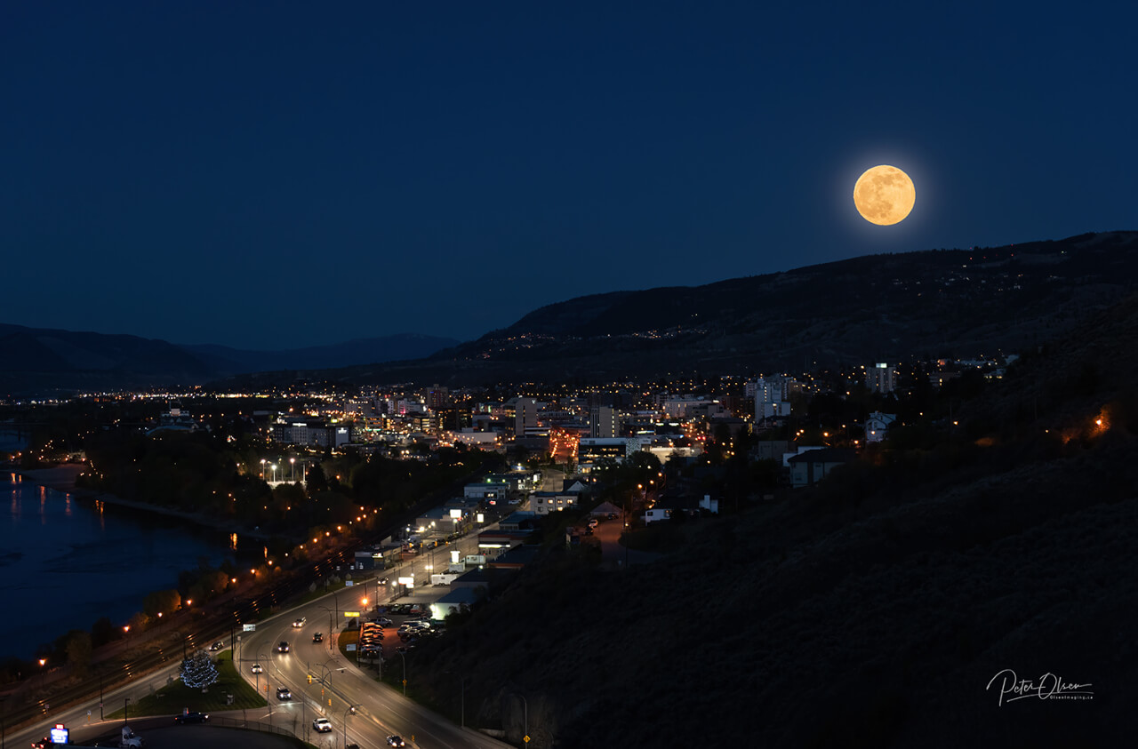 The mountain slope and city at night with road and full moon