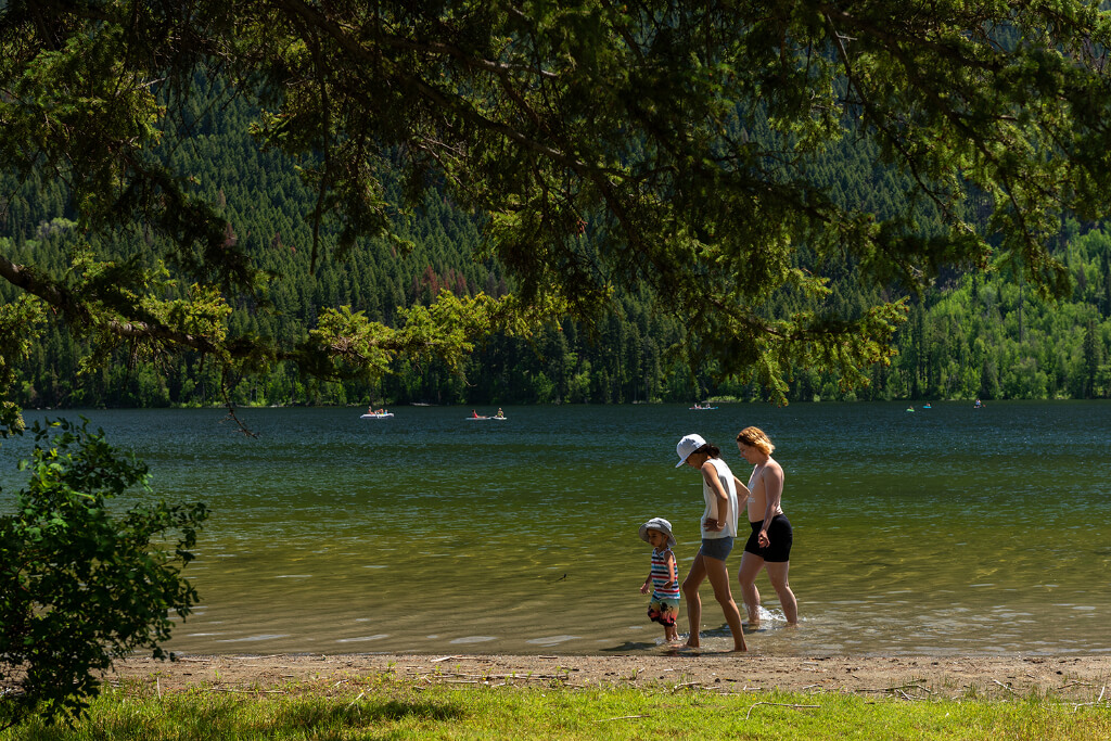 Adults and child walking along the lake shore