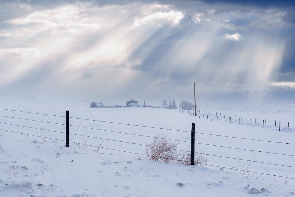 Snowy area with sunlight streaming through clouds