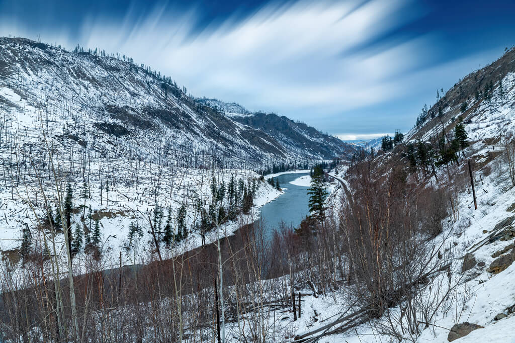 A river passing between the mountains covered with snow